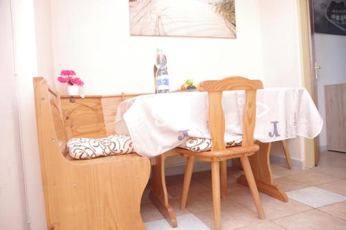 une table avec un chiffon de table blanc et deux chaises dans l'établissement Apartments Opsenica Barbat, à Barbat na Rabu