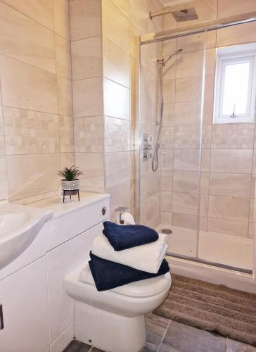 a bathroom with a toilet and a shower with towels at The Nook Cosby Village in Cosby