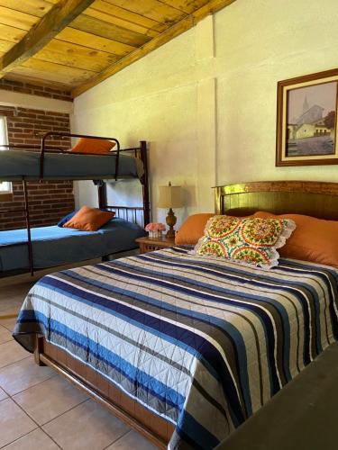 a bedroom with two bunk beds in a room at Cabañas Huerta la Mision, Zacatlán in Zacatlán