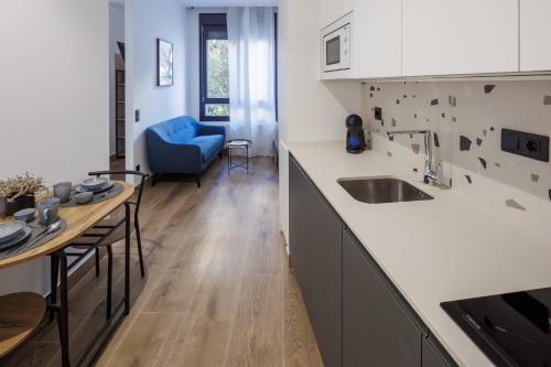 a kitchen with a table and a blue chair at Apartamentos Congreso, Parking gratuito in Logroño