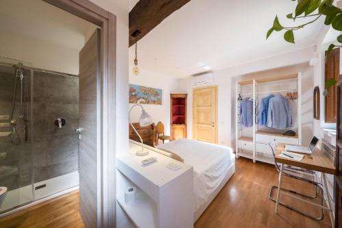 Habitación blanca con cama y ducha en Domus De Gorga - Your Sardinian Apartment, en Cagliari