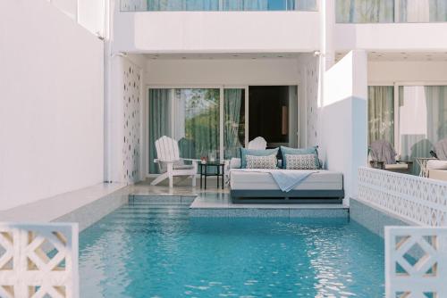 a house with a swimming pool and a living room at Kouros Exclusive Hotel & Suites - Adults Only in Faliraki