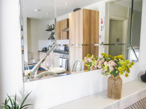 a kitchen with a mirror and a vase of flowers on a counter at Priory Place in Gloucester