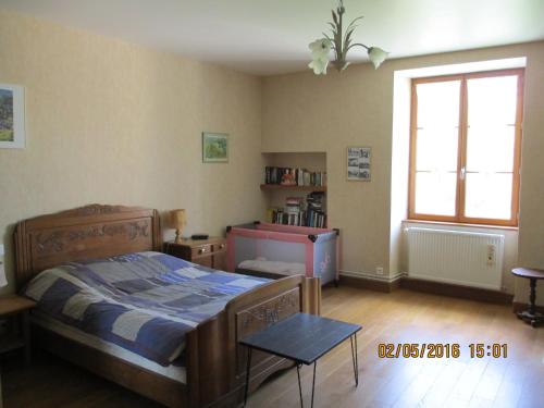 Schlafzimmer mit einem Bett, einem Tisch und einem Fenster in der Unterkunft Appartement La petite Résie in La Résie-Saint-Martin