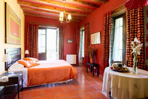 1 dormitorio con paredes rojas, 1 cama y 1 mesa en 6 bedrooms house with enclosed garden and wifi at Albella, en Albella