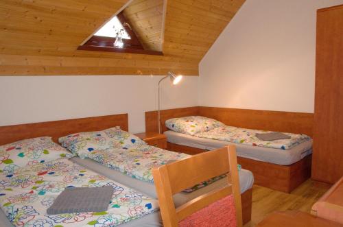 1 dormitorio con 2 camas, silla y ventana en Chata Soukenná, en Dolní Moravice