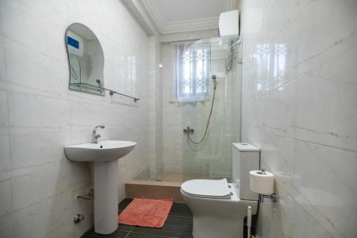 y baño con lavabo, aseo y ducha. en Executive Large Room with Ensuite, en Accra