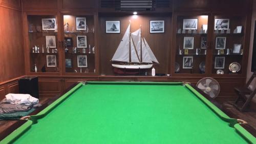 een kamer met een pooltafel en een boot aan de muur bij Tafelberg detached bungalow with swimming pool in Chiang Rai