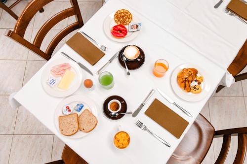 a white table with plates of food on it at Albergo Locanda Primavera in Rodengo Saiano