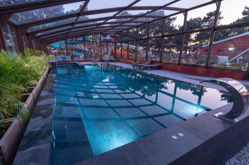 a swimming pool in a building with a swimming pool at Ohai Nazaré Outdoor Resort in Nazaré