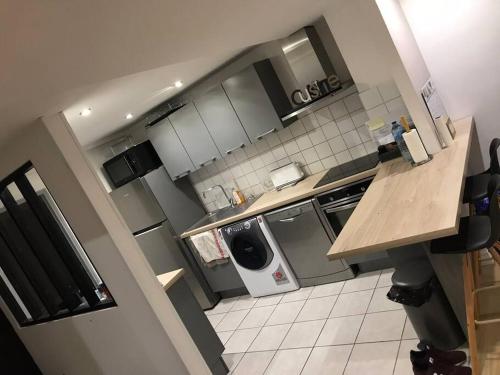 une petite cuisine avec lave-linge et sèche-linge dans l'établissement Très belle appartement plein centre ville, à Tourcoing