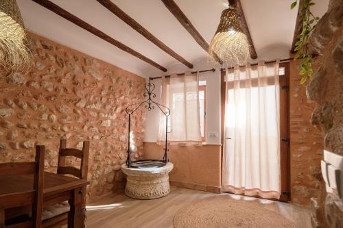 a room with a stone wall and a table and a toilet at Ca la tía Luisa in Gayanes