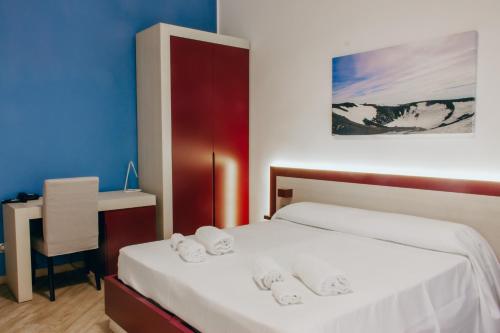 een slaapkamer met 2 bedden en een bureau met een stoel bij Guesthouse Lago di Nicito in Catania