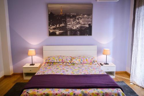 Un dormitorio con una cama con dos mesitas de noche y dos lámparas. en Policlinico Apartments, en Catania