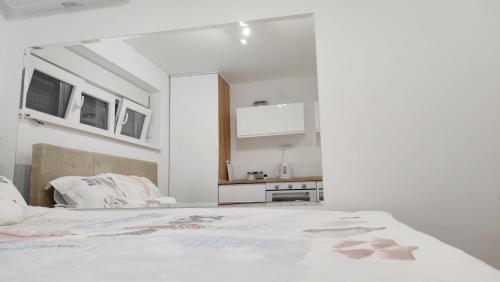 Milash في Karaburma: غرفة بيضاء مع سرير ومطبخ