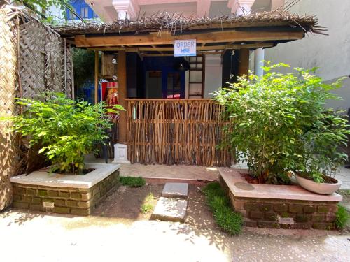 a house with a wooden gate and two bushes at Seconds Hostel - Colombo in Colombo