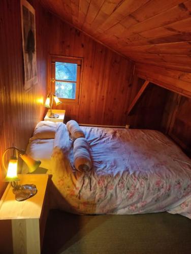 une chambre avec un lit dans une cabane en bois dans l'établissement Chalet accueillant et familial, à Saint-Martin-Vésubie