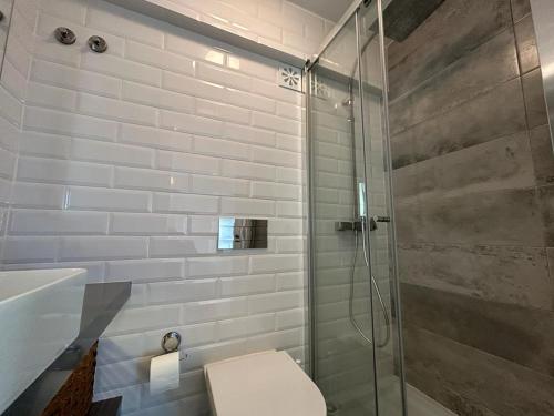 a bathroom with a toilet and a glass shower at Simply Yellow Apartment in Lisbon