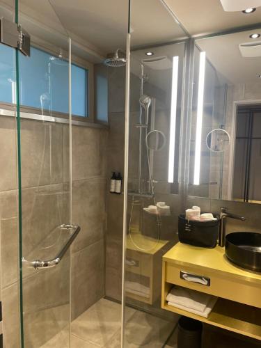 a bathroom with a glass shower and a sink at Scheck Hotel in Munich