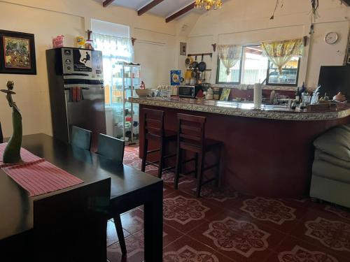 a kitchen with a counter and a bar in a room at Pure Canyoning Home in Turrialba