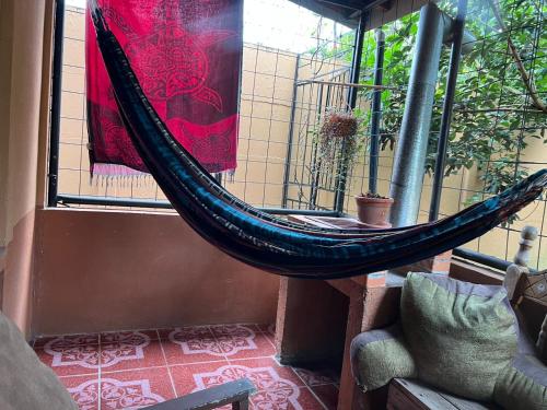 a hammock hanging from a window in a room at Pure Canyoning Home in Turrialba