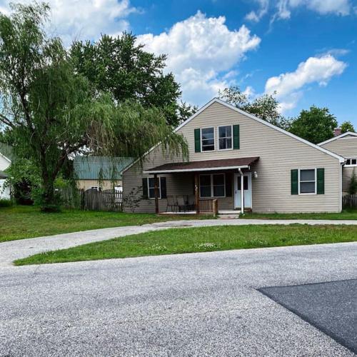 a white house with green windows and a driveway at Entire Private 2 bedrooms house, nice neighborhood in Arnold