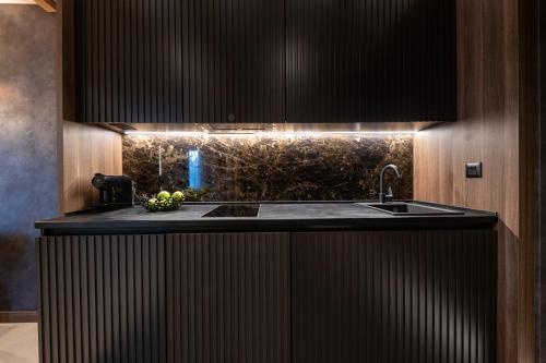 - une cuisine avec un comptoir noir et un évier dans l'établissement Woodside Residence 325, à Kopaonik
