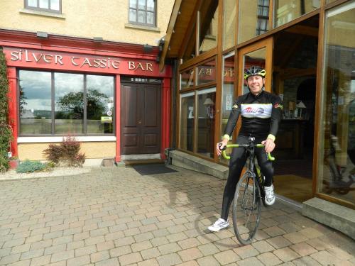 a man riding a bike in front of a building at Silver Tassie Hotel & Spa in Letterkenny
