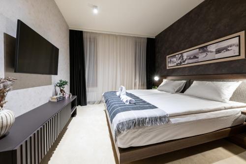 - une chambre avec un grand lit et une télévision dans l'établissement Woodside Residence 325, à Kopaonik