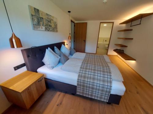 a bedroom with a bed with a plaid blanket on it at SchartnerAlm in Collalbo