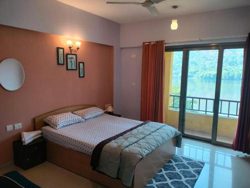a bedroom with a bed and a large window at PORTOFINO in Lavasa