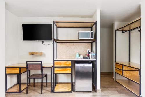 een kamer met een bureau en een keuken met een televisie bij Lago Zirahuén By HomiRent in Mexico-Stad