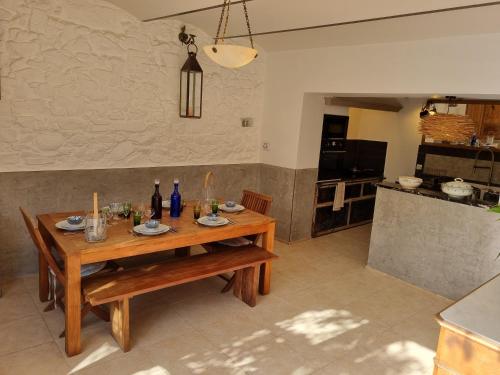 a kitchen with a wooden table in a room at Mas de la Petite Jeanne in Grimaud