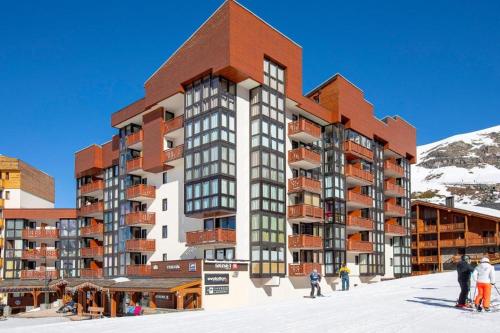 a building with people standing in the snow in front of it at Les appartements de Makalu Val Thorens in Val Thorens