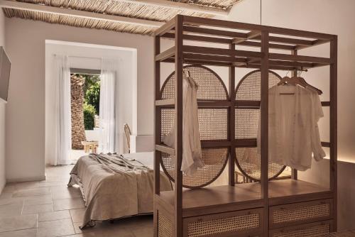 a bedroom with a wooden bunk bed with clothes in it at Dionysos Seaside Resort Ios in Mylopotas