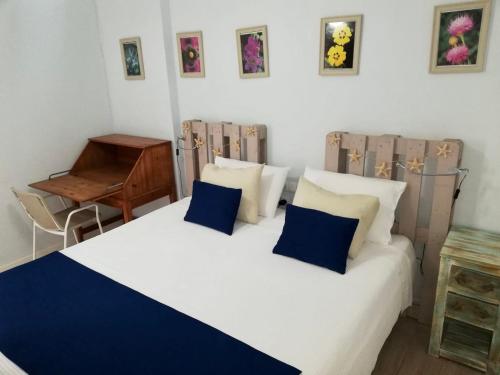 um quarto com uma cama com almofadas azuis e brancas em Casa Elena em Candelaria