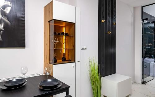 a dining room with a table and a cabinet at LoveRoom Panorama Park Jacuzzi in Białystok