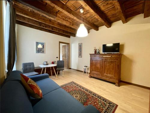 ein Wohnzimmer mit einem blauen Sofa und einem TV in der Unterkunft Casa Collini Salò in Salò