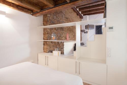 a bedroom with white cabinets and a stone wall at Habitat Apartments Alissia in Barcelona