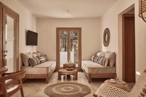 a living room with a couch and a chair at Dionysos Seaside Resort Ios in Mylopotas