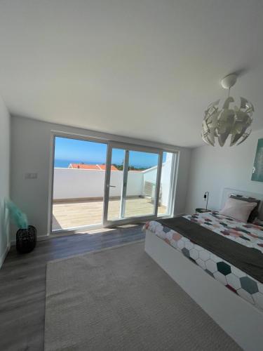 a bedroom with a bed and a large window at Paraíso do Sítio 2 in Nazaré