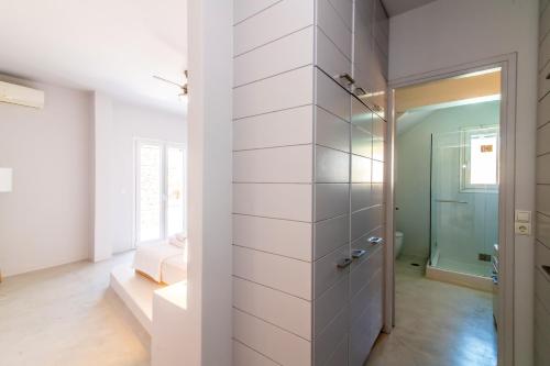 a bathroom with white walls and a walk in shower at Epsilon Villa by TinosHost in Tinos Town