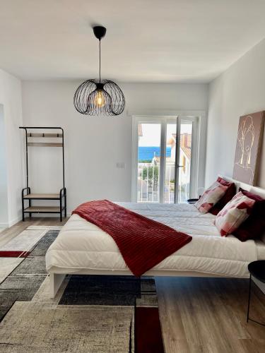 a white bedroom with a large bed and a window at Paraíso do Sítio 2 in Nazaré