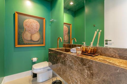 baño con aseo y pared verde en Vista parcial do MAR em ótima localização #CA24, en Florianópolis