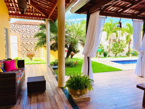 a living room with a couch and a patio at Villa Paradise in Brazil - Praia de Guaratiba Prado-BA in Prado