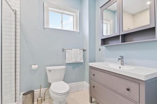 a bathroom with a toilet and a sink and a mirror at Bright and Spacious Condo in Downtown Collingwood 97043 in Collingwood