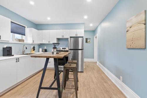 a kitchen with a table and a refrigerator at Bright and Spacious Condo in Downtown Collingwood 97043 in Collingwood