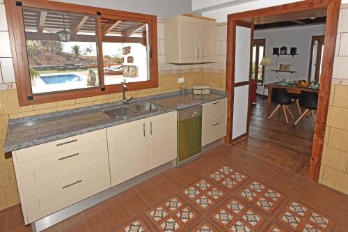 a kitchen with a sink and a kitchen with a pool at Casa La Florida in Puntagorda