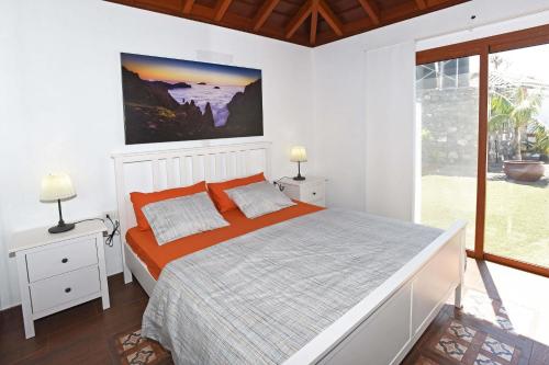ein Schlafzimmer mit einem Bett und einem großen Fenster in der Unterkunft Casa La Florida in Puntagorda