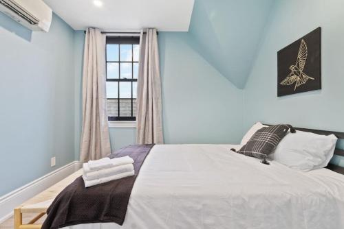Schlafzimmer mit einem Bett mit blauen Wänden und einem Fenster in der Unterkunft Luxury Contemporary Condo in Downtown Collingwood 97044 in Collingwood